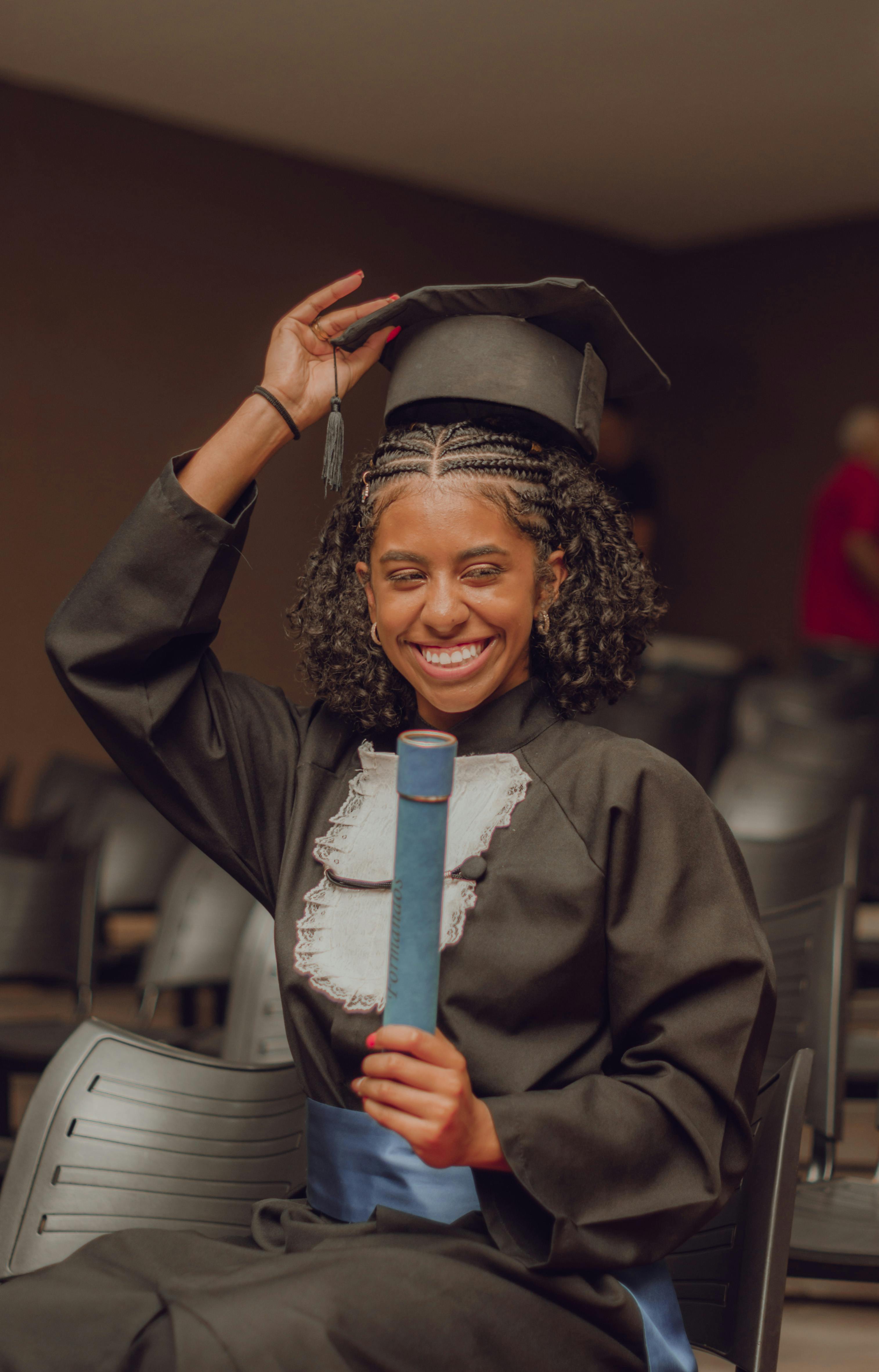 Formanda com capelo e diploma sorrindo — A&R Cerimonial